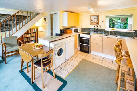 Kitchen with cooker, washing machine, dining table and breakfast bar