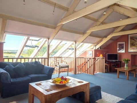 Lounge area with beamed ceiling, sofa, coffee table, tv