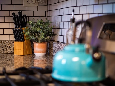 Bright, modern kitchen with crisp white cabinets, granite countertops, and subway tile backsplash. Stainless appliances and patterned wood-look floors flow seamlessly into the adjacent dining room for effortless entertaining! 🍽️✨🏡
