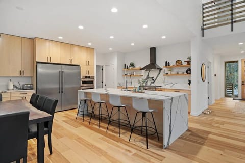 Kitchen features 10' waterfall island, side by side fridge and freezer, wall oven with microwave, 36" gas range with 6 burners.