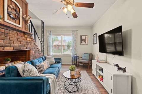Cozy living room w/ plush seating, brick fireplace & wall-mounted TV for relaxed evenings indoors