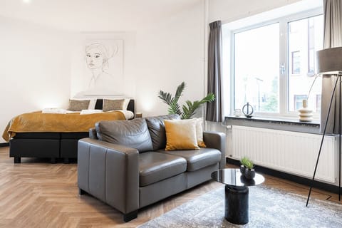 A cozy and spacious living area with a comfy sofa perfect for a cheap getaway—whether you're overnighting at Efteling, visiting Safaripark Beekse Bergen, or just exploring the city.