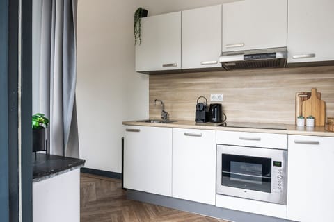 A bright and functional kitchen with clean, white cabinetry, centrally located and wallet-friendly—Hotel Tilburg is perfect for your Efteling or safari park getaway.