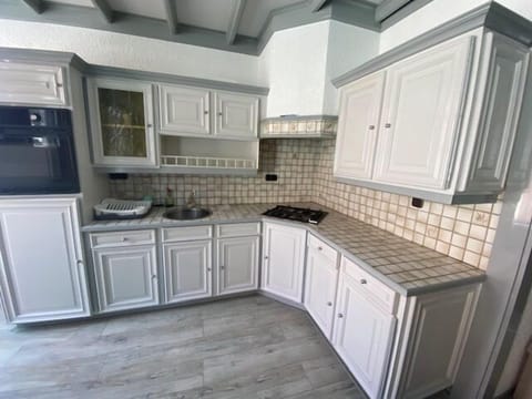 A spacious and bright kitchen with classic white cabinetry and modern appliances, offering a welcoming space for culinary creativity.