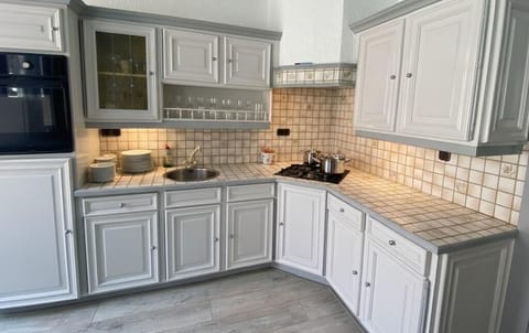 A spacious and bright kitchen with classic white cabinetry and modern appliances, offering a welcoming space for culinary creativity.
