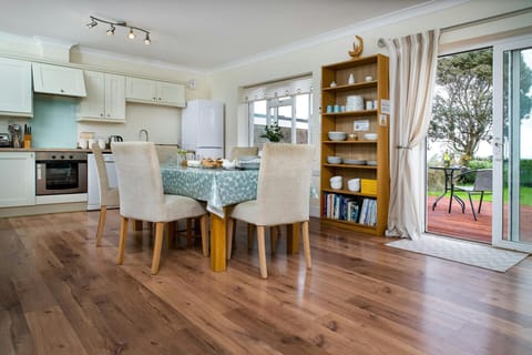 Safe Haven living area with dining table and chairs, kitchen, patio doors