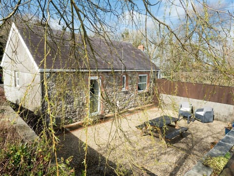 Outside at The Old Forge, gravel patio area with picnic bench and outdoor armchairs