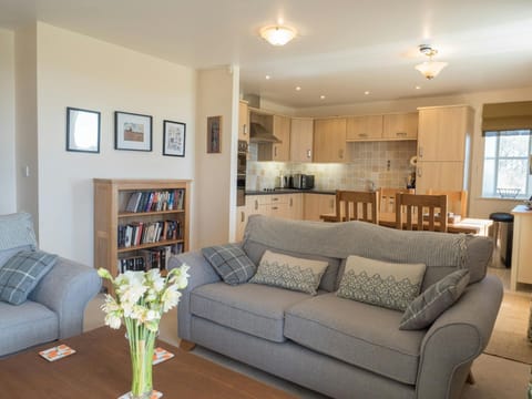 Bright living room in St Brides View with sofas, dining table, chairs and kitchen