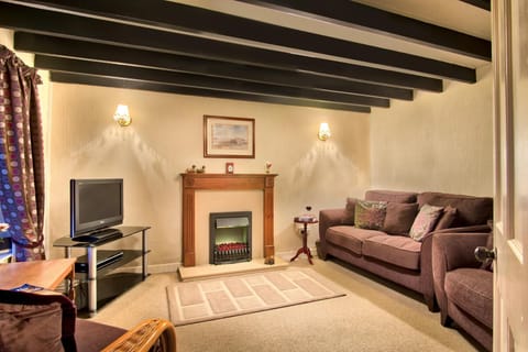 Sitting room with a 3 seater sofa and armchairs, TV/DVD and electric fire