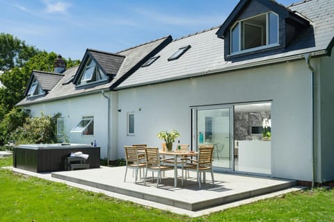 Garden with lawn, 6-seater hot tub and patio furniture.