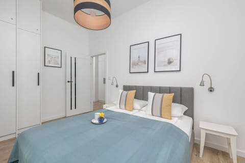 Cozy bedroom with a large bed, decorative pillows, and a wall clock.