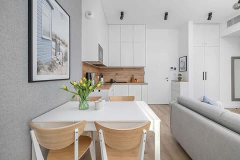 White minimalist kitchen with wooden countertops and modern appliances.