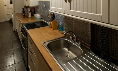 Long kitchen cabinet, oven and hob, sink and drainer