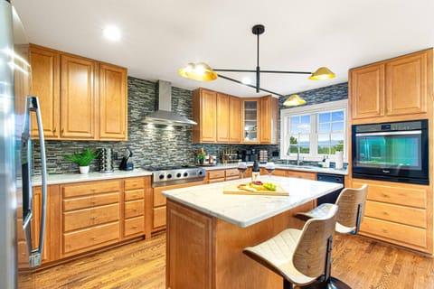 Prepare meals in this modern kitchen featuring sleek appliances, a spacious island, and plenty of natural light. Perfect for gatherings and gourmet cooking!