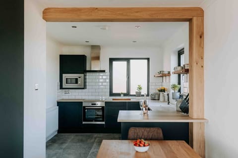 Ty Melyn Newgale – Cook in style with our fully equipped kitchen featuring sleek cabinetry, modern appliances, and an open layout perfect for entertaining.