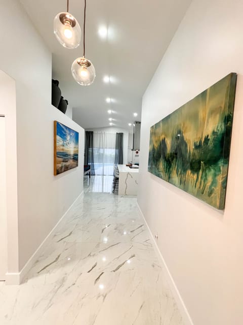 Entrance hallway with new tile floors, high ceiling and lots of portlights