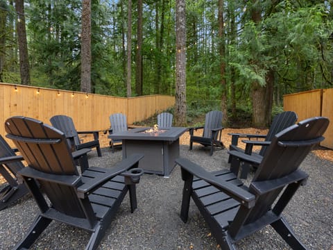 Gather 'round the warm fire pit in comfy Adirondack chairs! Perfect for cozy evenings and making memories.