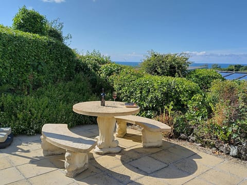 Stone table and benches on the patio with distant sea views