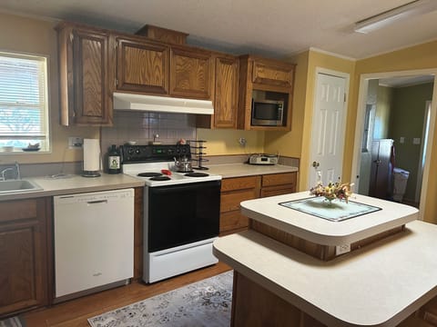 Large family style kitchen with dishes, cooking utensils provided