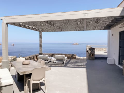 Private side terrace with loungers and dining table