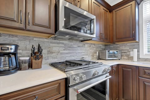 Microwave and stove in main kitchen with coffee maker and air fryer