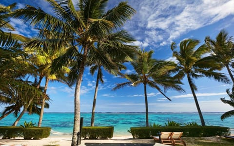 On the beach, white sand, sun loungers, beach towels