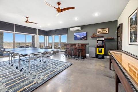 Game room featuring a ping pong table, a shuffleboard table, and arcade games!