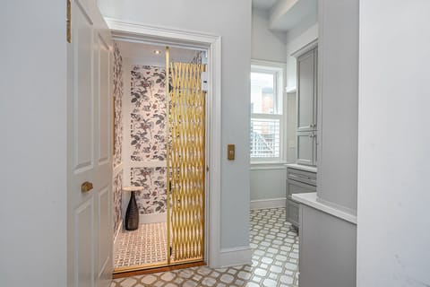 At the back of the home, an elevator will ascend you to the third floor or ground level of the home.