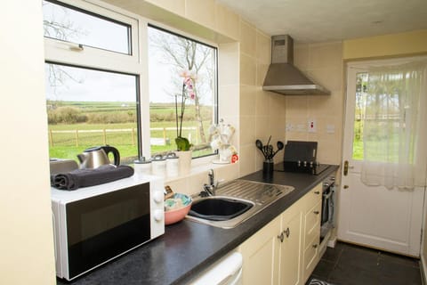 Kitchen area, microwave, kettle, extractor fan and oven.Window looking out to countryside