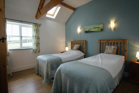Twin room with beds, bedside cabinets, lamps and countryside views from the window