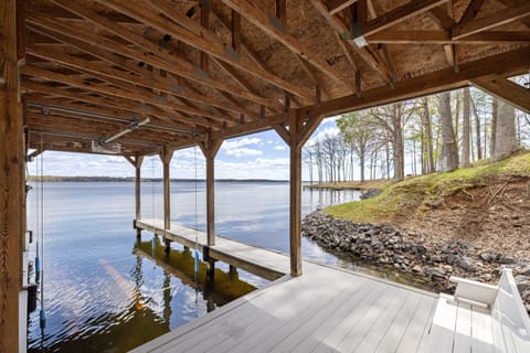 Rustic under-deck view showcasing a peaceful dock and the expansive beauty of the lake beyond