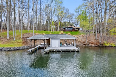 Waterfront property with a private dock and a cozy cabin surrounded by trees