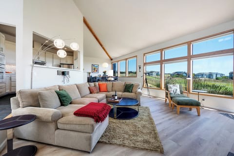 Open floor plan living space with large windows that maximize the view of the golf course and ocean.