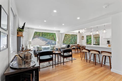 - Open living area with large windows and scenic forest views  
- Modern layout connects living dining and kitchen together  
- Perfect for gatherings with family and friends indoors  
