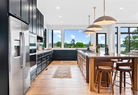 Cooking is a joy in this spacious kitchen, complete with sleek black cabinets and vibrant art. The open layout is perfect for entertaining.