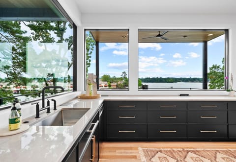 This kitchen’s open layout and stylish decor make it the heart of the home. The combination of dark cabinetry and light wood floors creates a welcoming atmosphere.