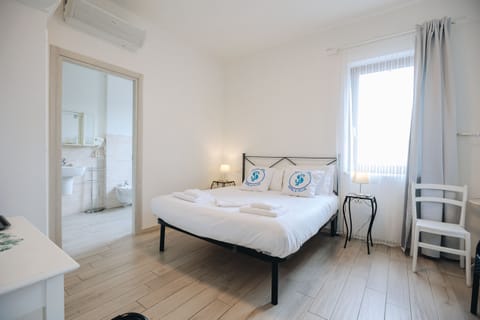 Bright double room with private bathroom, furnished in a modern style and equipped with air conditioning for a comfortable stay.