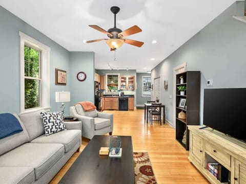 Living room with comfortable seating looks out into scenic back yard.