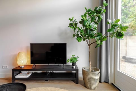 Modern living area with a sleek TV setup creating a relaxing and refreshing ambiance,  perfect for a budget-friendly stay near Tilburg Center, the university, Efteling & Beekse Bergen.