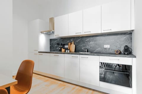 Modern kitchen with sleek white cabinetry, marble backsplash, and fully equipped for preparing delicious meals during your stay.

Studio appartement in Tilburg met gloednieuwe keuken – ideaal voor goedkoop overnachten vlakbij Tilburg Centrum, de universiteit, Efteling & Safaripark Beekse Bergen.
