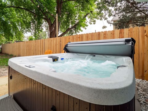 Refreshing private hot tub with bubbling jets for ultimate relaxation   - Surrounded by a tall wooden fence offering privacy and comfort   - Ideal for unwinding after exploring local attractions nearby
