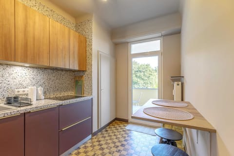 Stylish kitchen with direct access to the balcony, featuring top-of-the-line appliances and a convenient dining area. Enjoy cooking with a view.