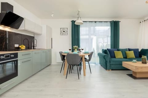 Living room with a fold-out sofa bed, dining area and kitchenette.