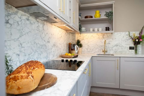 Kitchen area with electric oven and hob. Wall and base cupboards