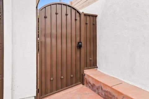 Front entrance is the side gate to the left of the garages. Key pad code entry system.