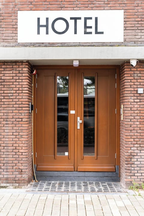 The main entrance of the hotel, featuring a classic brick facade and welcoming wooden doors.

Blijf centraal en bespaar geld bij Hotel Tilburg! Ideaal voor Efteling avonturen, Beekse Bergen uitstapjes, of het verkennen van Tilburg zelf.