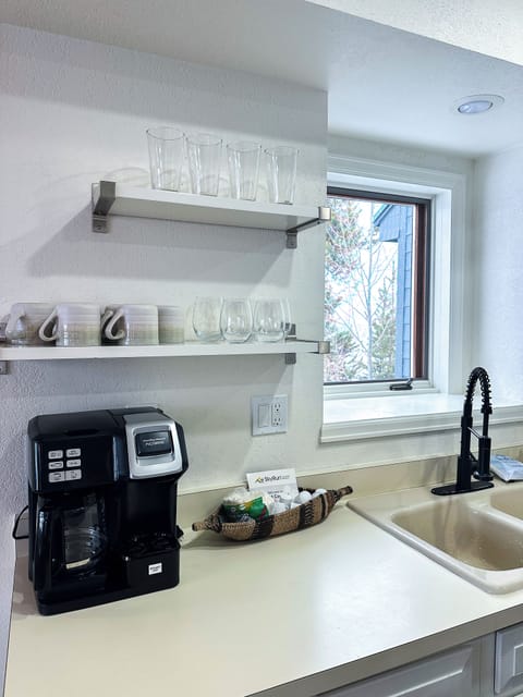 - Start your day with drip or pod coffee options from this compact station - Floating shelves above hold mugs and glassware for every guest’s needs - Positioned next to the sink and window to make mornings bright and breezy