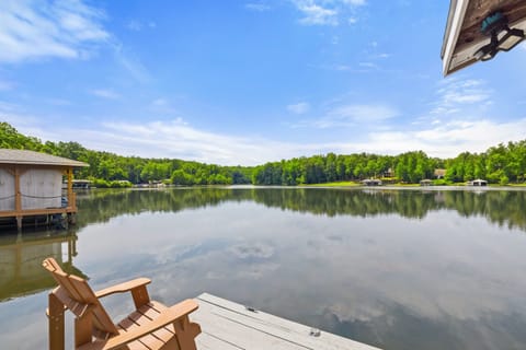 A serene lakeside view from a dock equipped with Adirondack chairs, perfect for enjoying peaceful moments by the water.