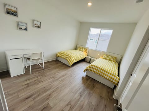 spacious guest room with 2 twin beds and working desk