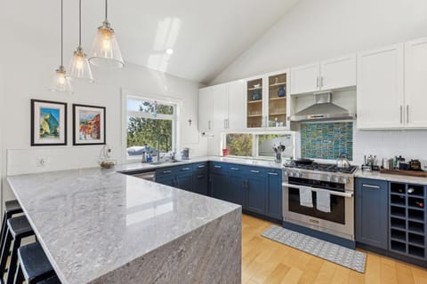 Large kitchen with quartz countertops and professional grade range.